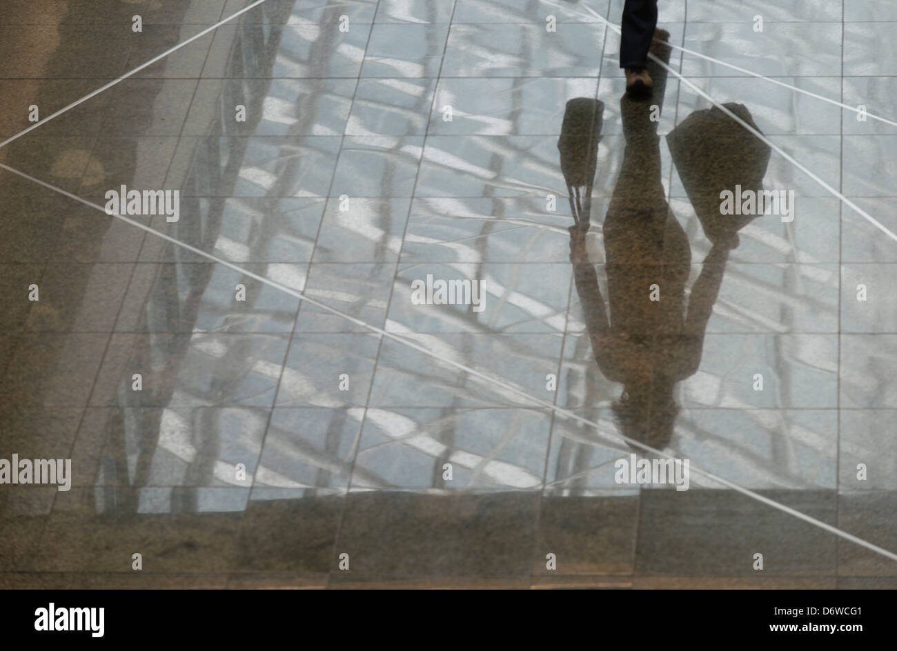 a reflection of a woman carrying shopping bags in a shopping centre Stock Photo