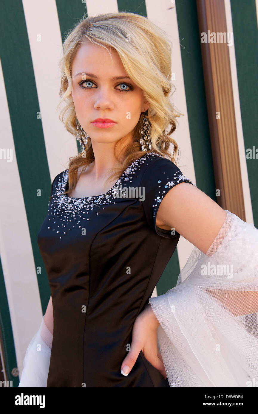 Blond Model Stares Into The Camera Wearing A Black Prom Dress And