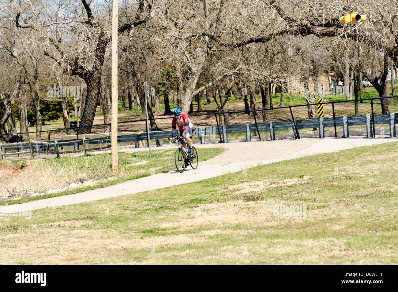 A senior man rides his bicycle on trails by the North Canadian river and Overholser lake in the Oklahoma City, Oklahoma, USA  area. Stock Photo