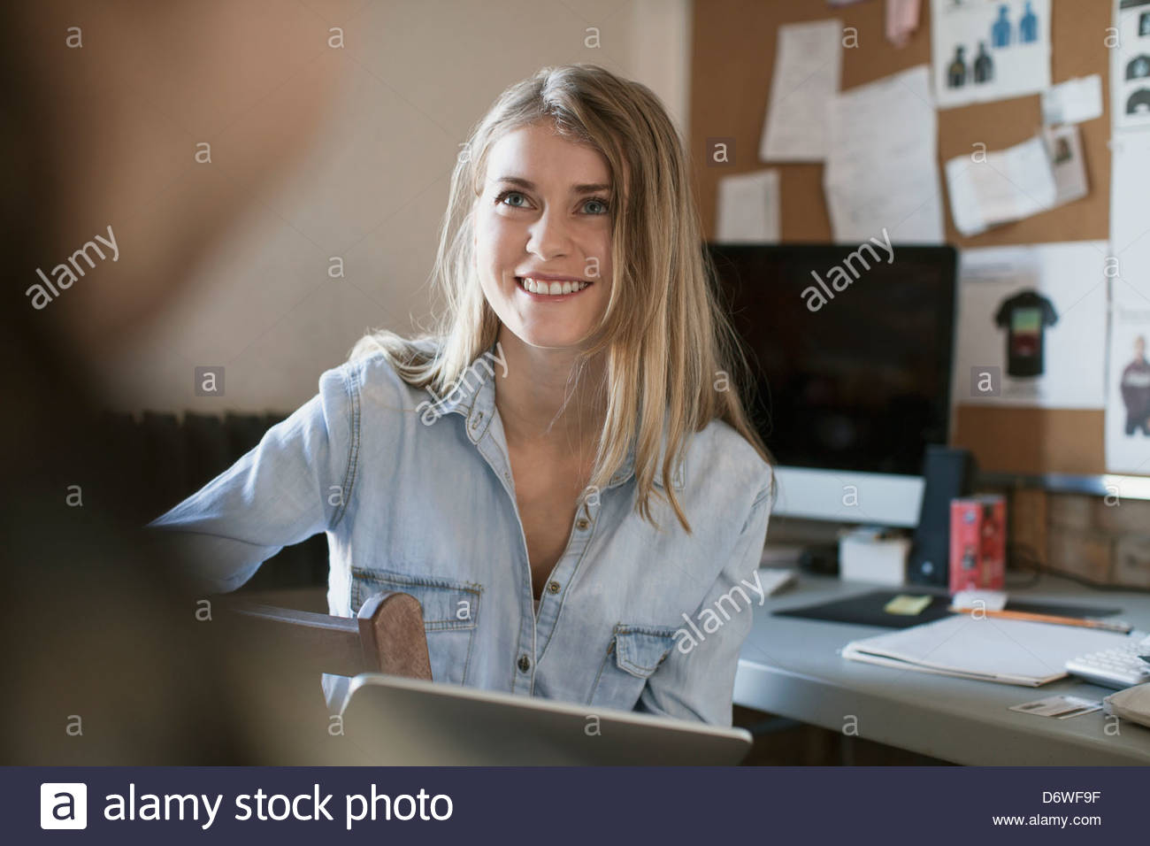 Happy female design professional at desk Stock Photo