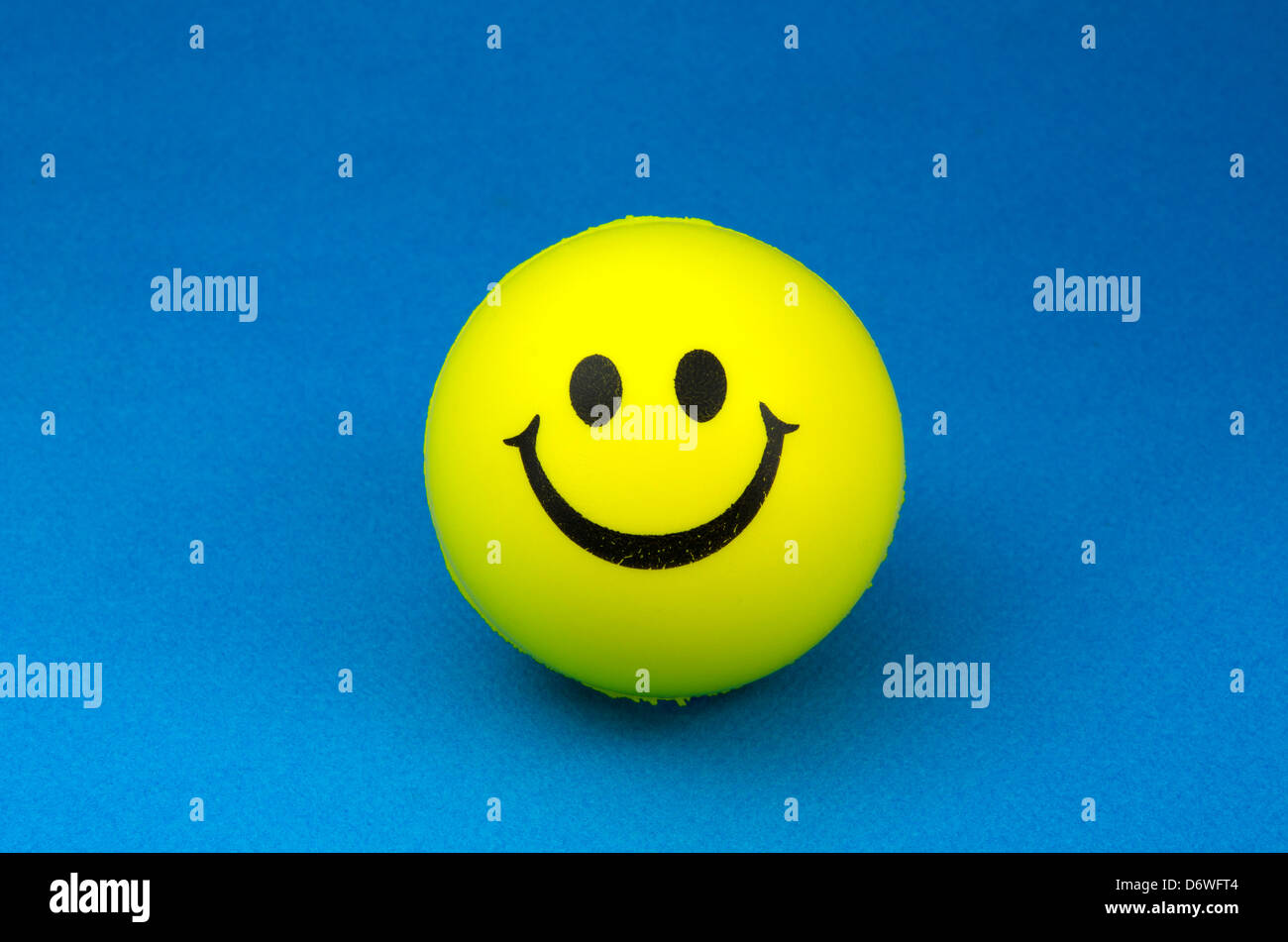 Yellow smiley face on blue background Stock Photo