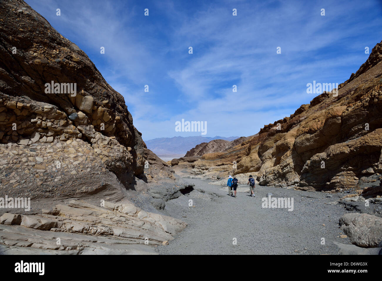 Hikers walk on the dry river bed at Mosaic Canyon. Death Valley National Park, California, USA. Stock Photo