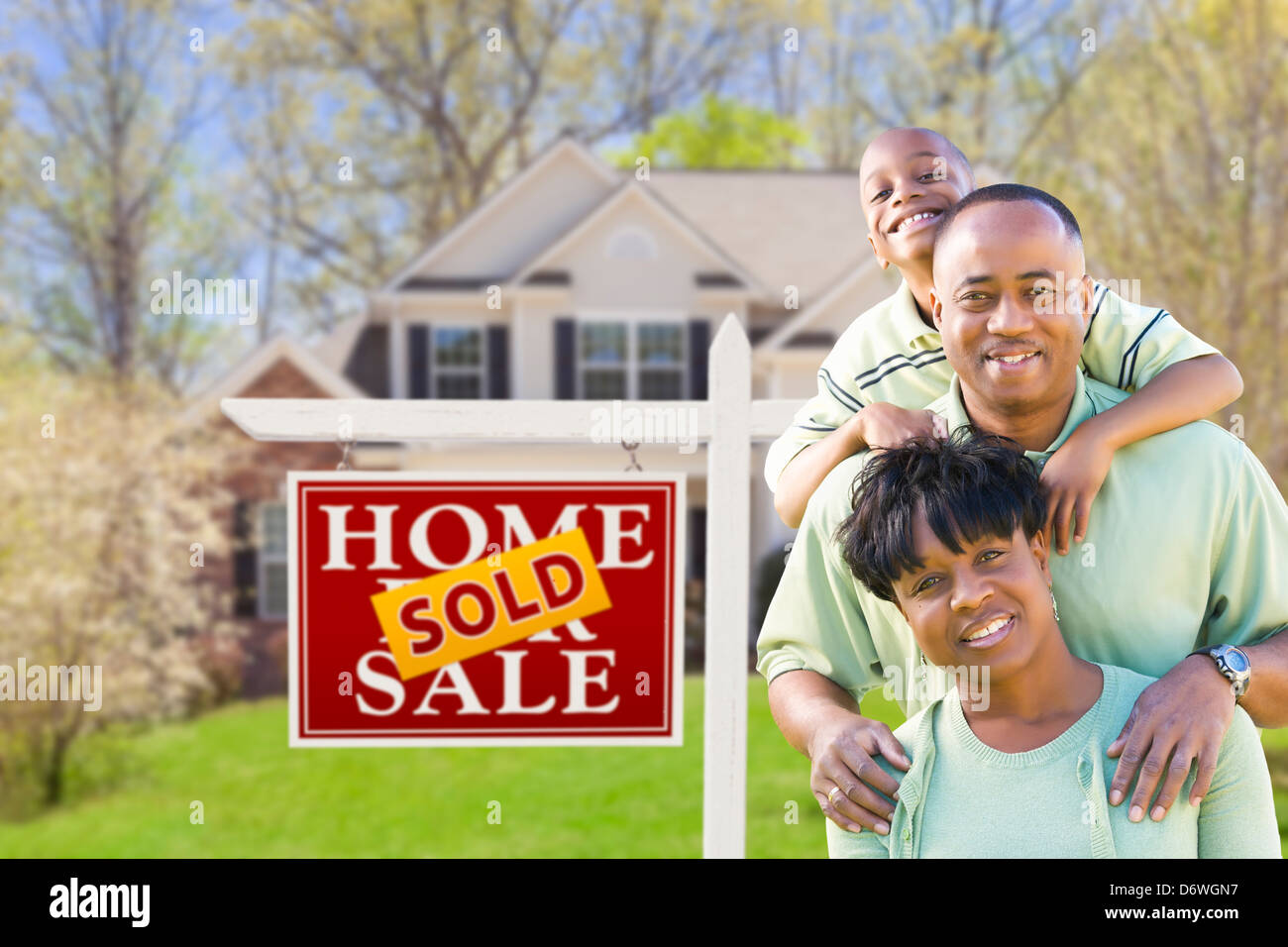 Happy African American Family In Front of Sold Real Estate Sign and ...