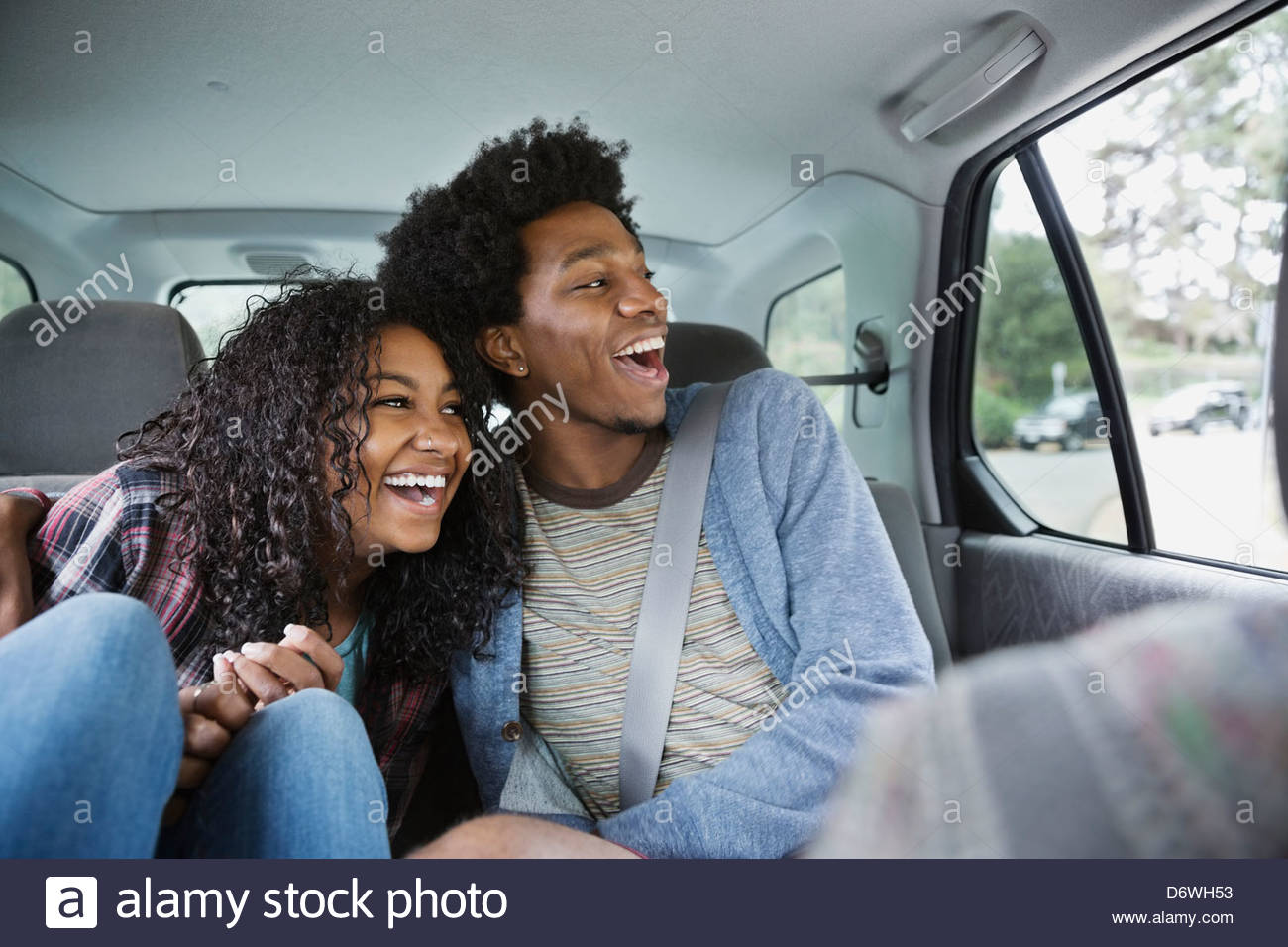 Cheerful couple looking through window while enjoying road trip Stock Photo