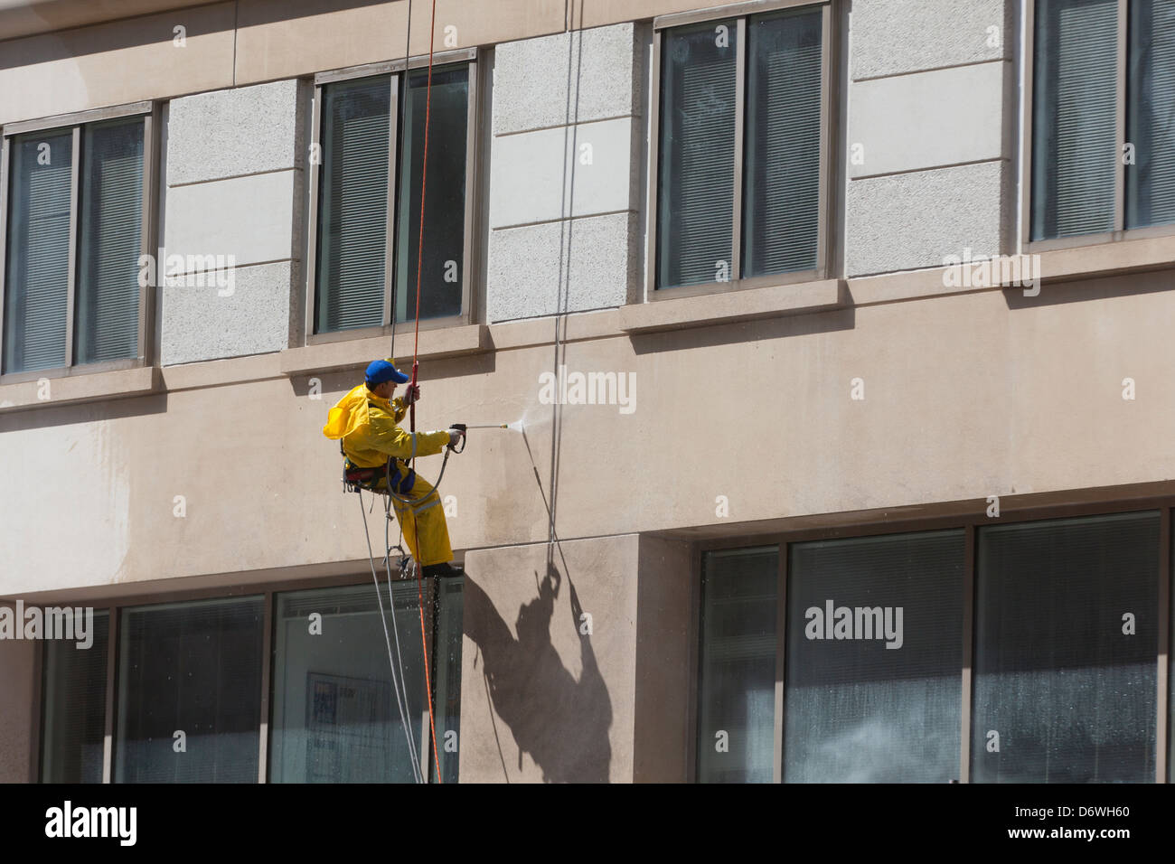 Man cleaning building with pressure washer Stock Photo