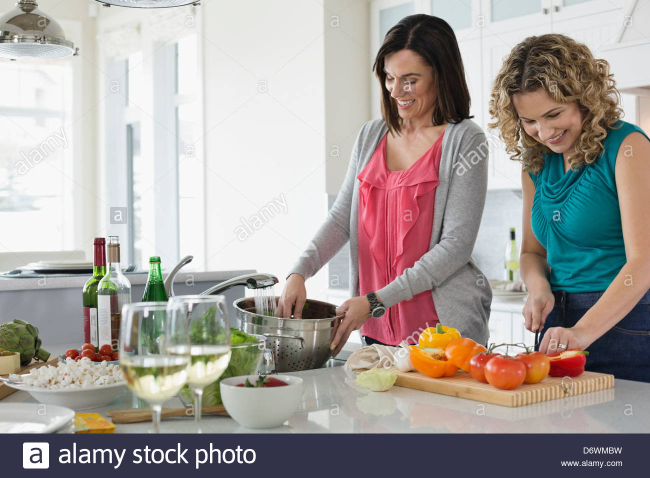 Happy mature women cooking together in kitchen Stock Photo