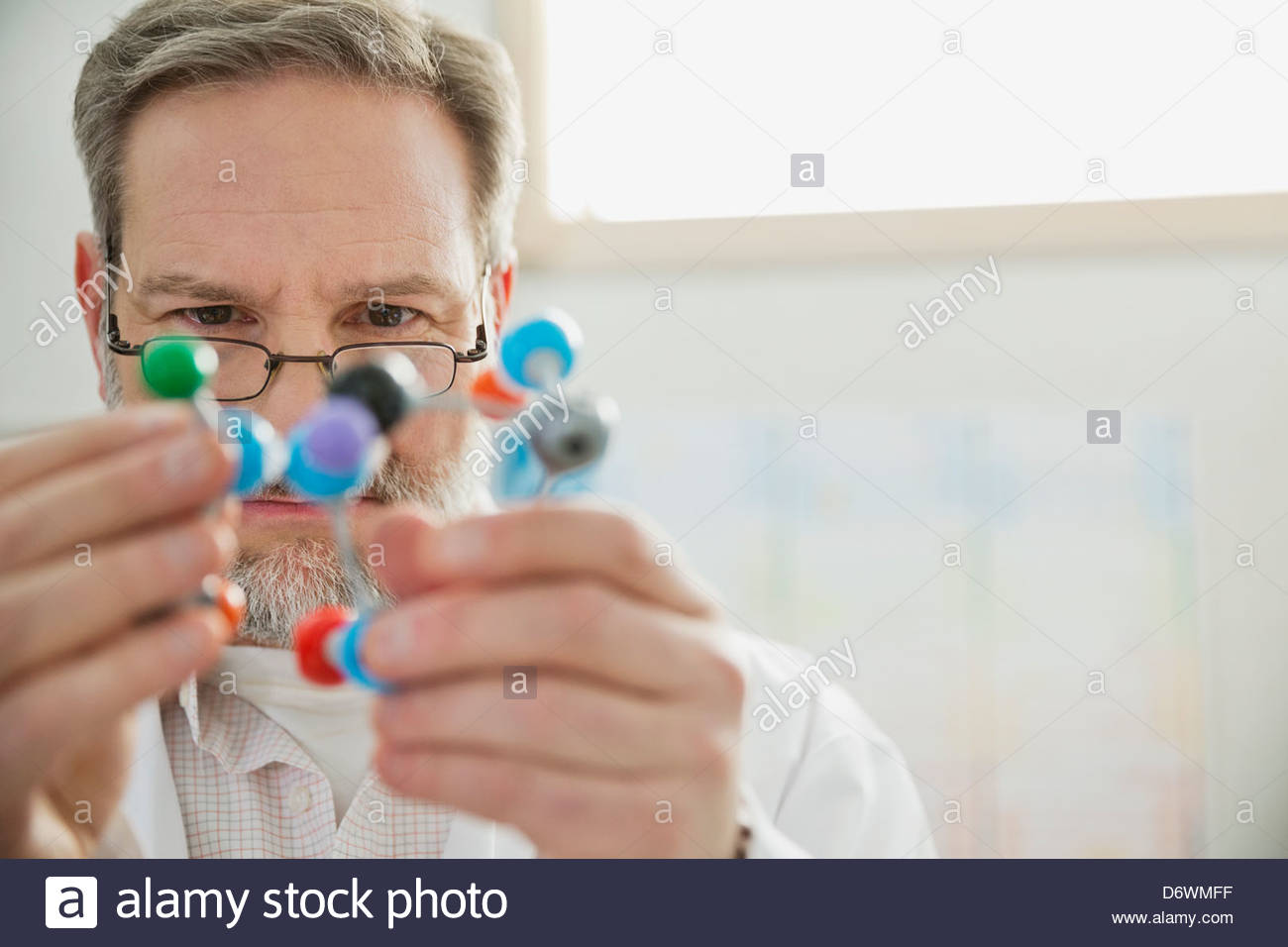 Mature male chemist examining molecular model in lab Stock Photo
