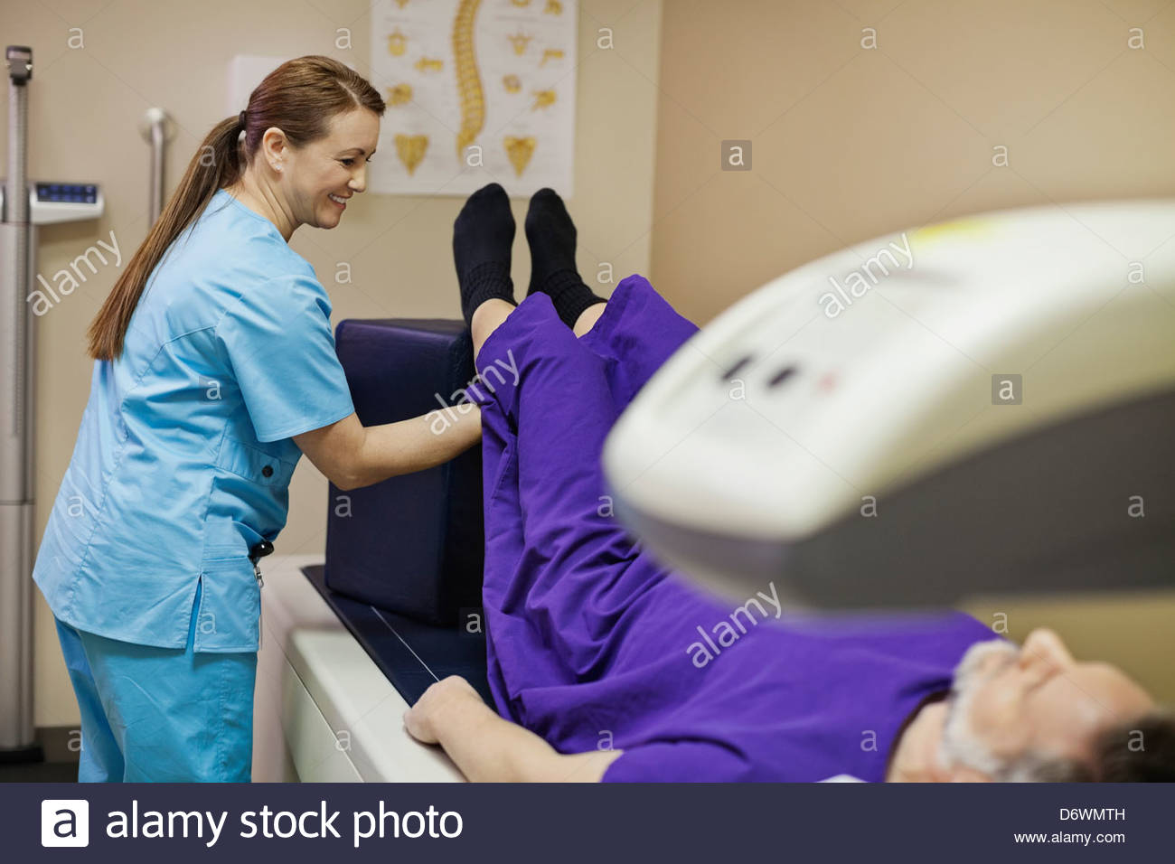 Technologist prepping patient for bone density scan in examination room Stock Photo