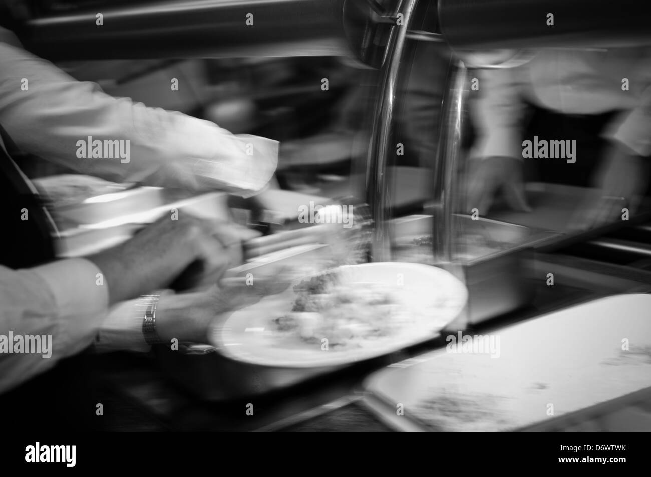 Blurred image of caterers serving hot food in a canteen Stock Photo Alamy