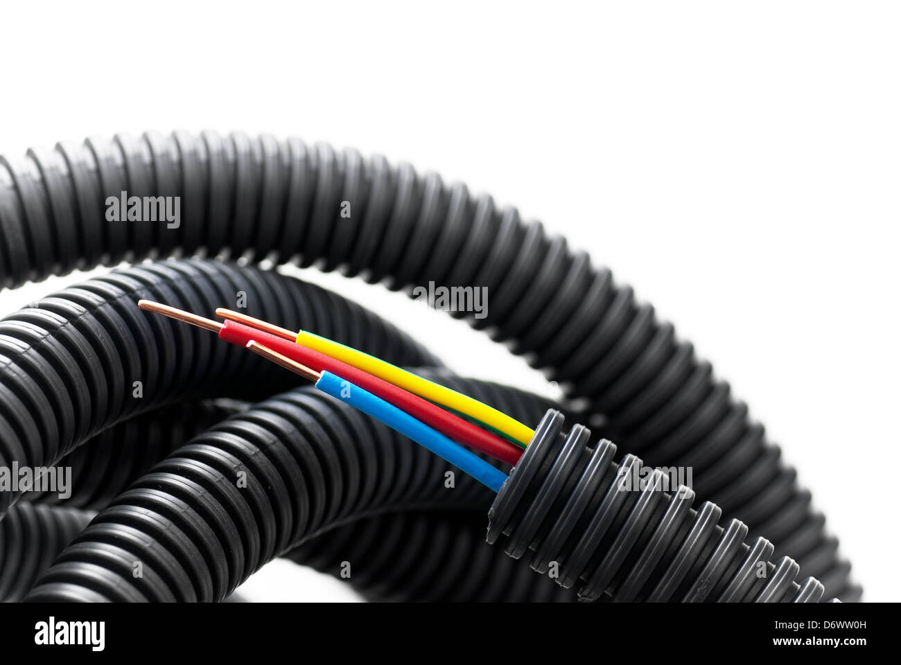 stripped copper cable inside a black flexible corrugated tube Stock Photo