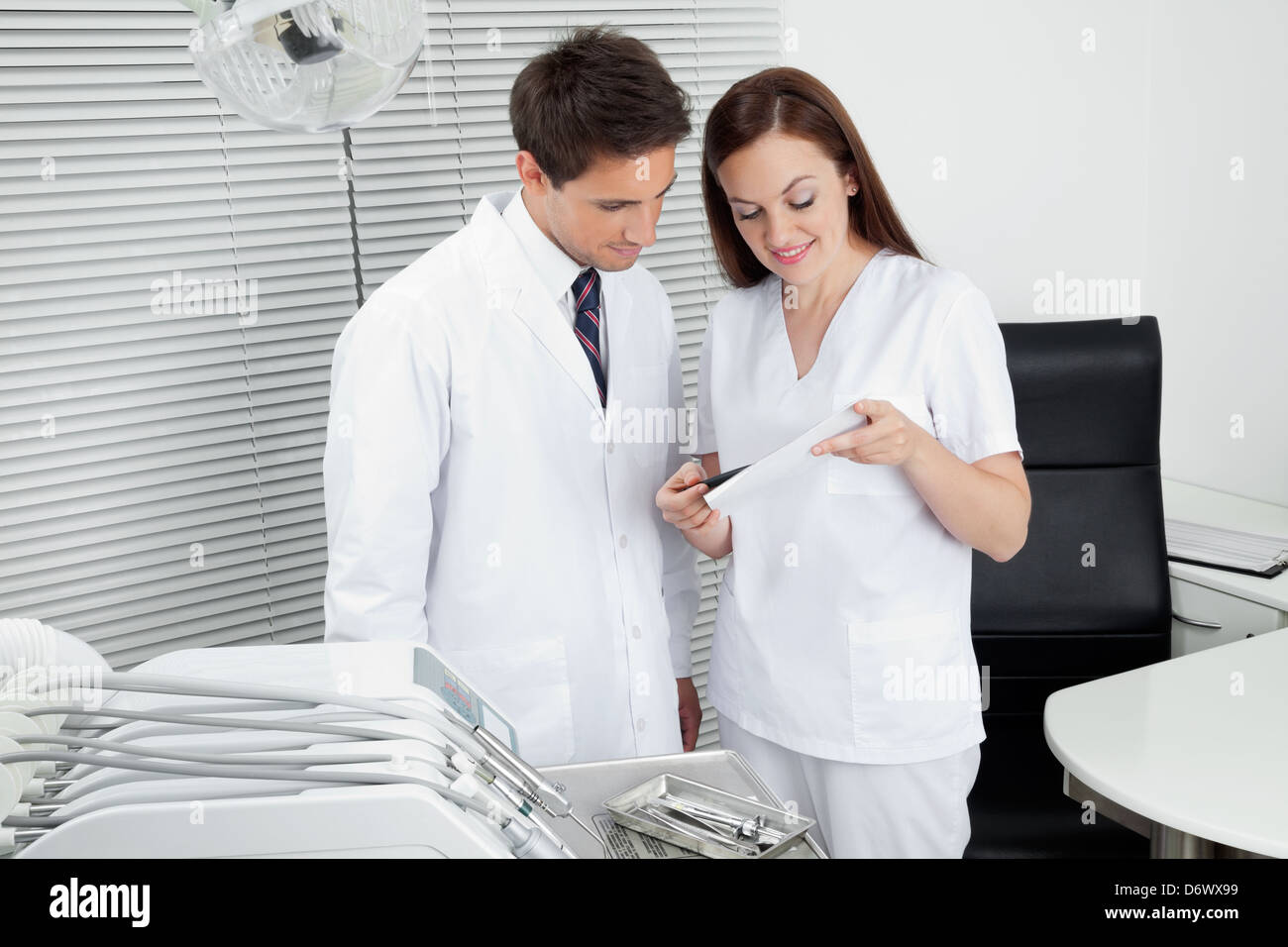 Dentist And Assistant With Dental Report Stock Photo