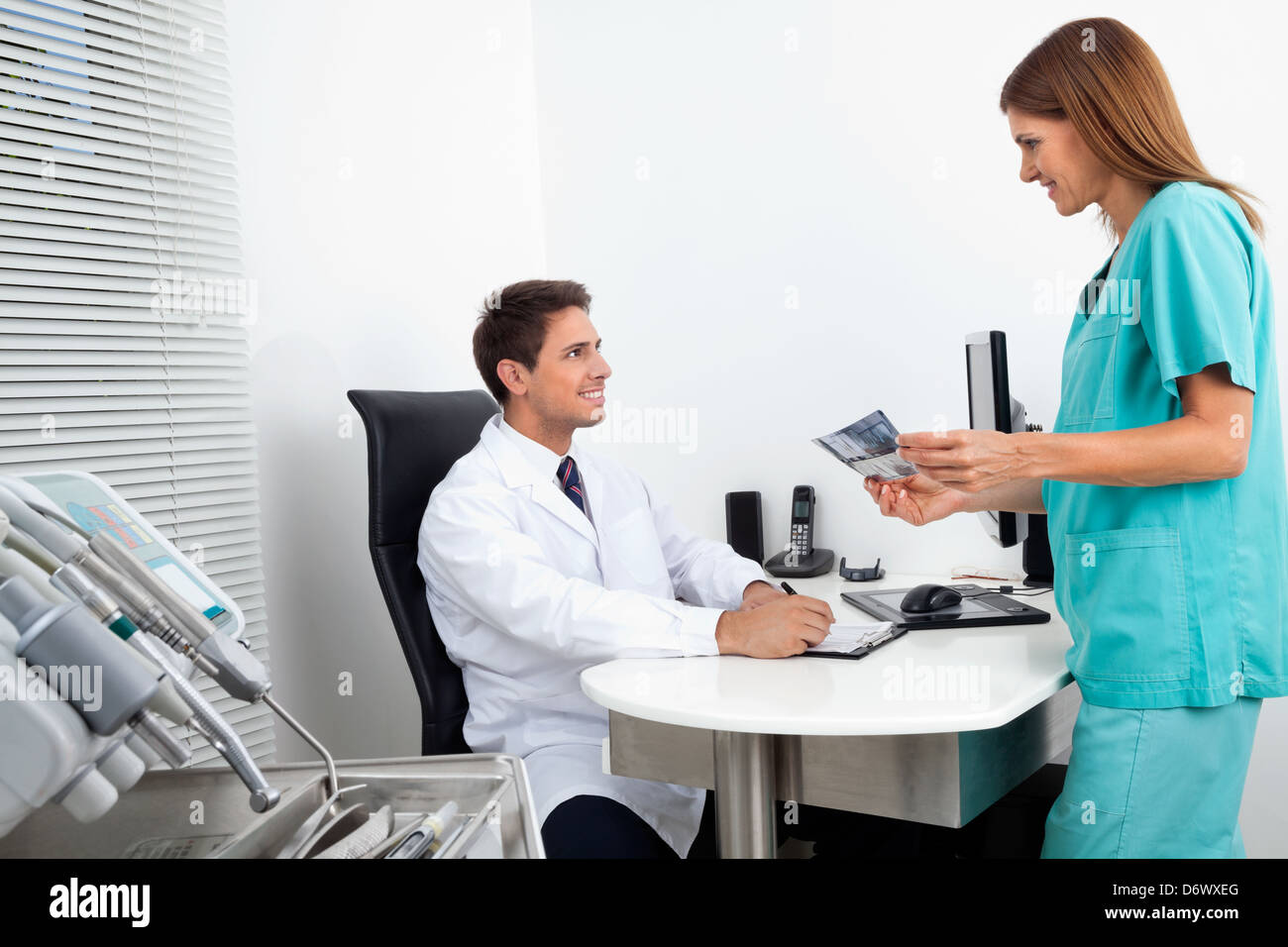 Doctor And Assistant With Dental Report Stock Photo