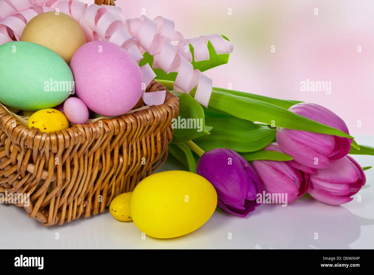 Large and small different colour Easter eggs in a basket. Stock Photo