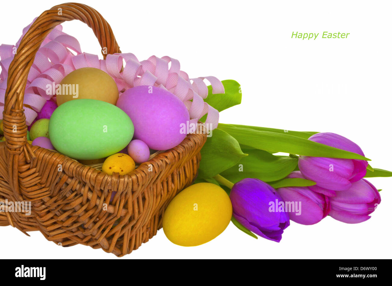 Wicker basket with colored eggs and flowers. Stock Photo