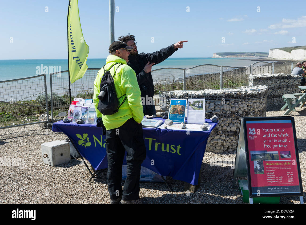 A member of the National Trust giving directions to a walker at Birling Gap. Stock Photo