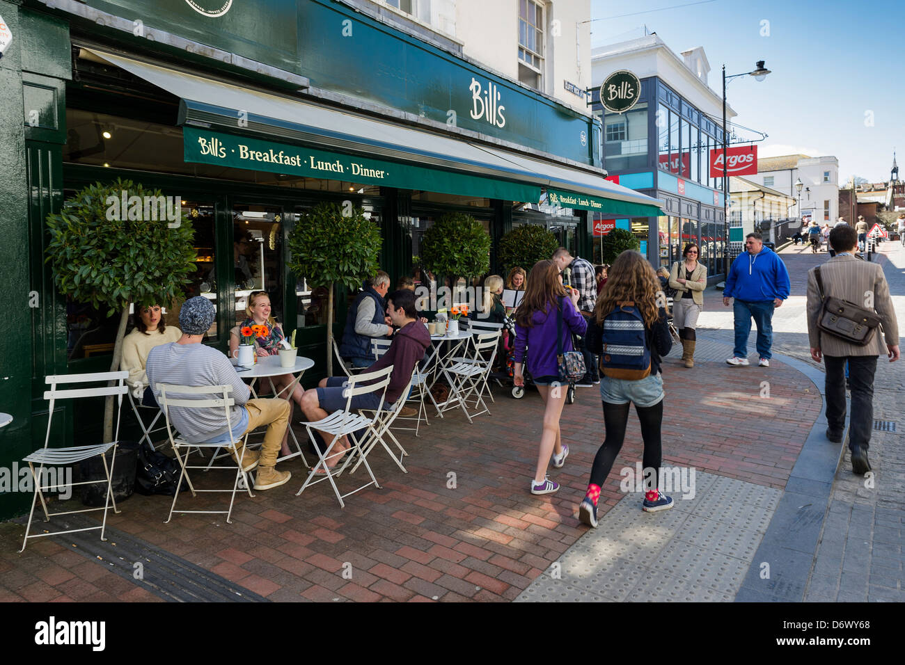 People sitting at tables outside Bills restaurant in Cliffe High Street in Lewes. Stock Photo