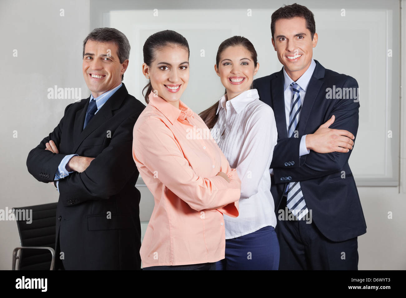 Dynamic happy busines team standing in the office with the arms crossed ...