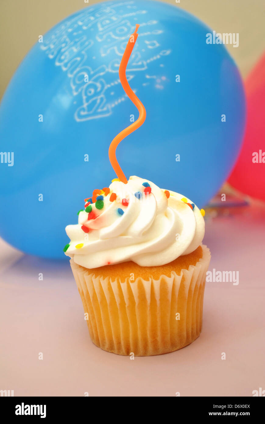 Birthday Cupcake with an Orange Candle Stock Photo