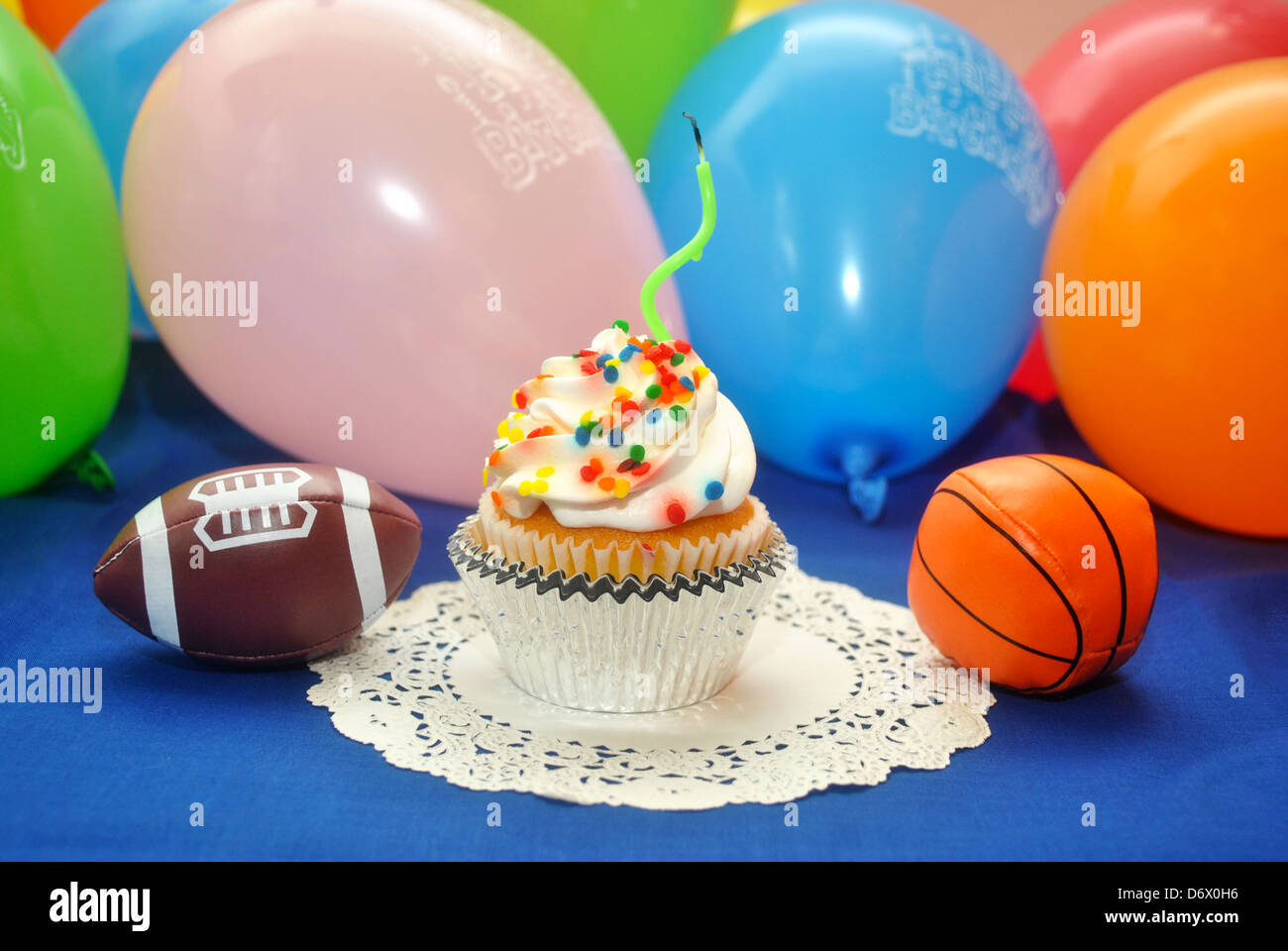 Bithday Cupcake with 1 Candle and a Toy Football and Basketball Stock Photo