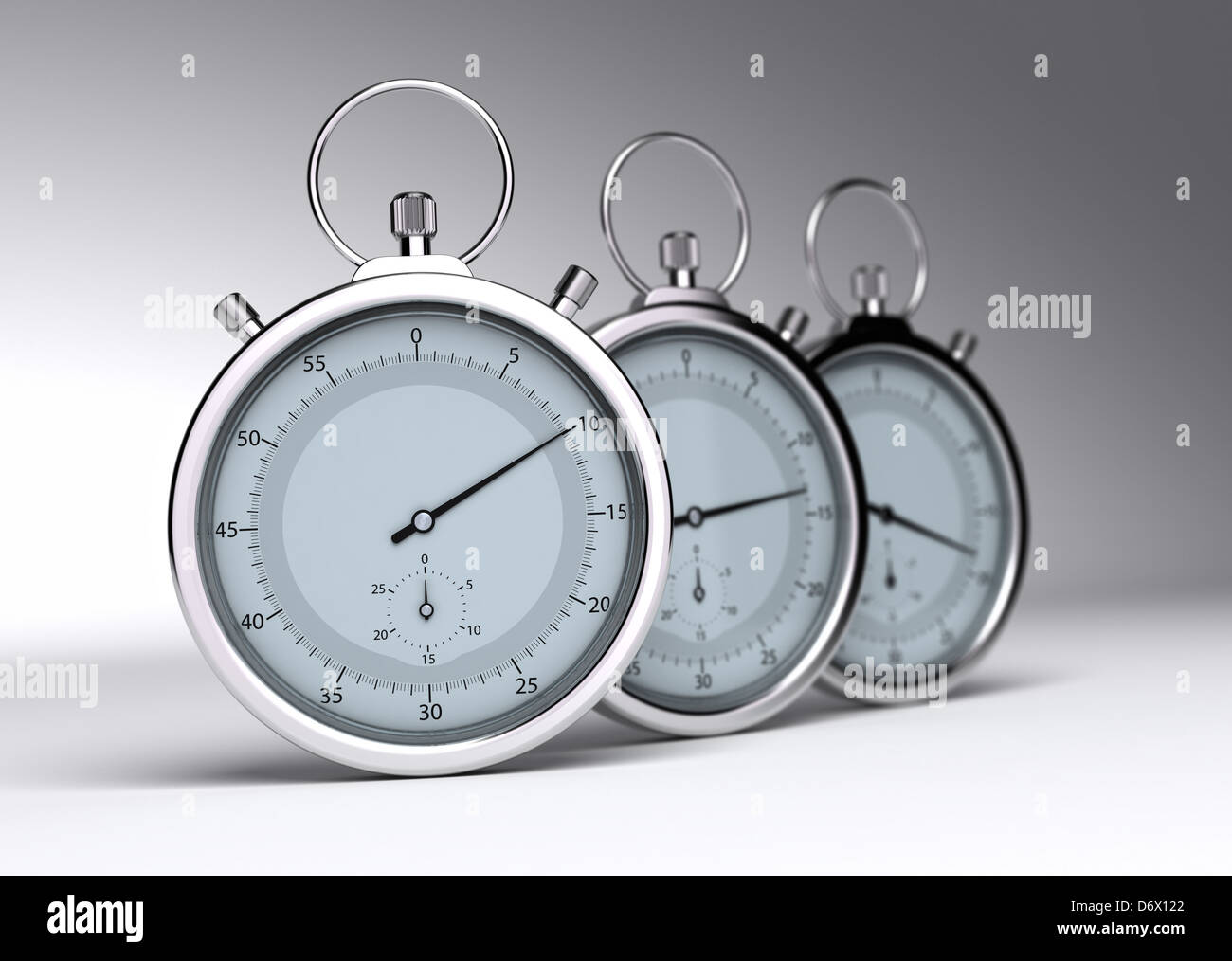 three stopwatches over a grey background with blur Stock Photo