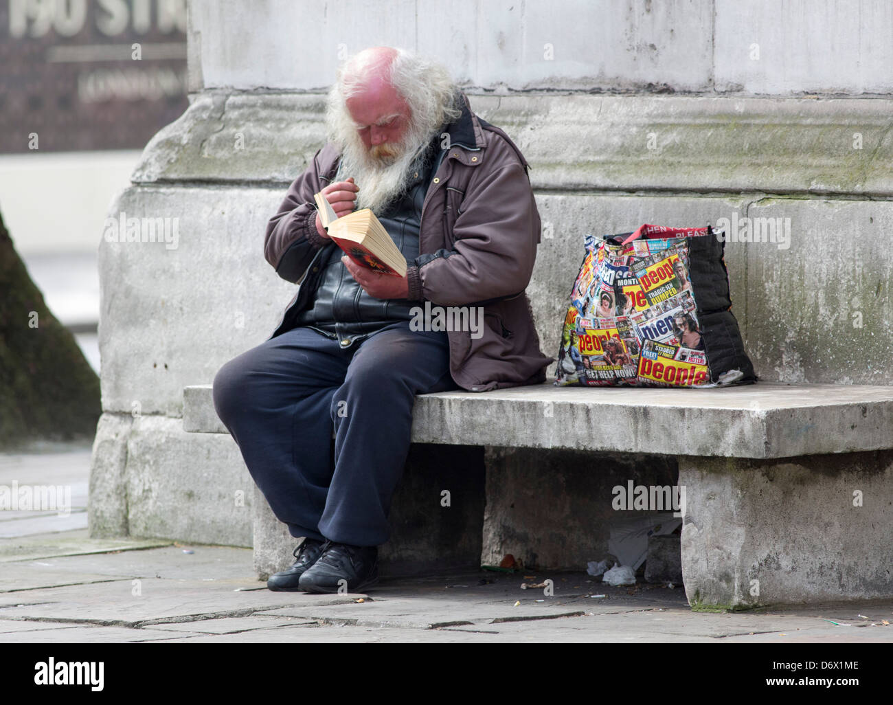 A tramp reading a book in London Stock Photo