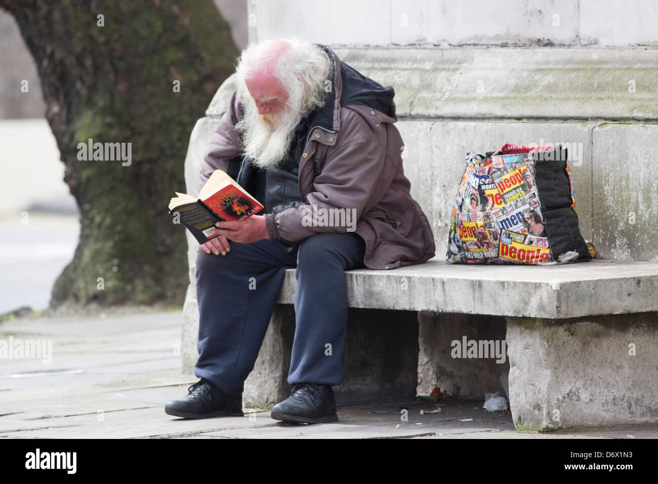 A tramp reading a book in London Stock Photo