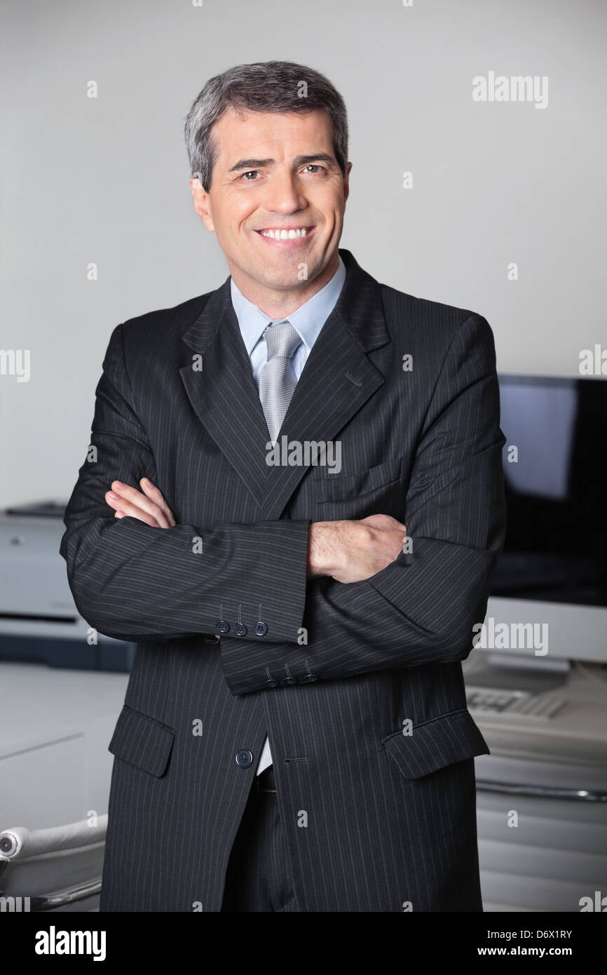 Successful business man smiling with his arms crossed Stock Photo - Alamy