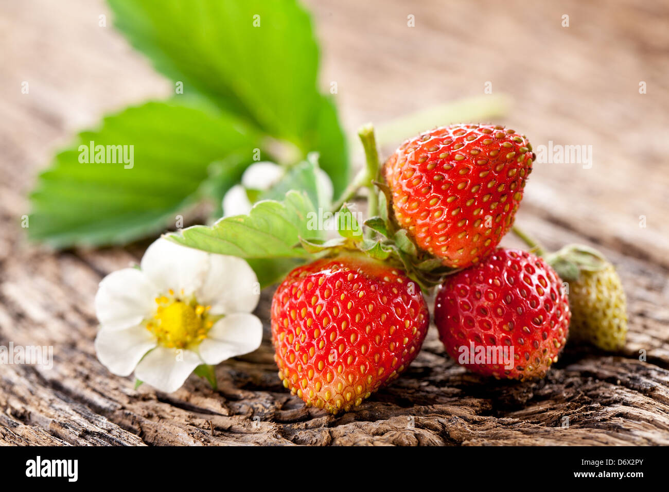 Strawberries with leaves on the old wooden table Stock Photo - Alamy