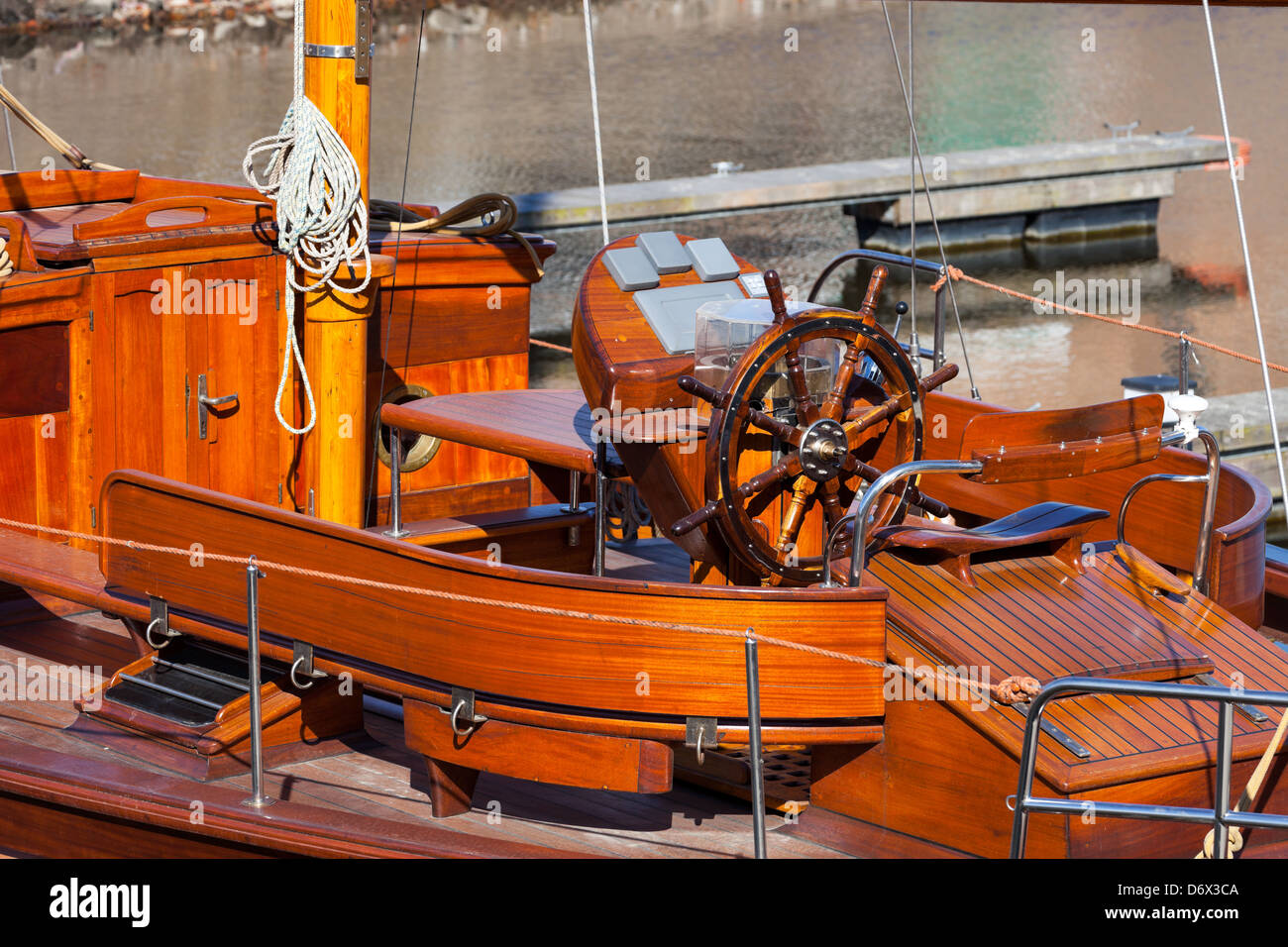 Captains steering wheel on wooden yacht. Stock Photo