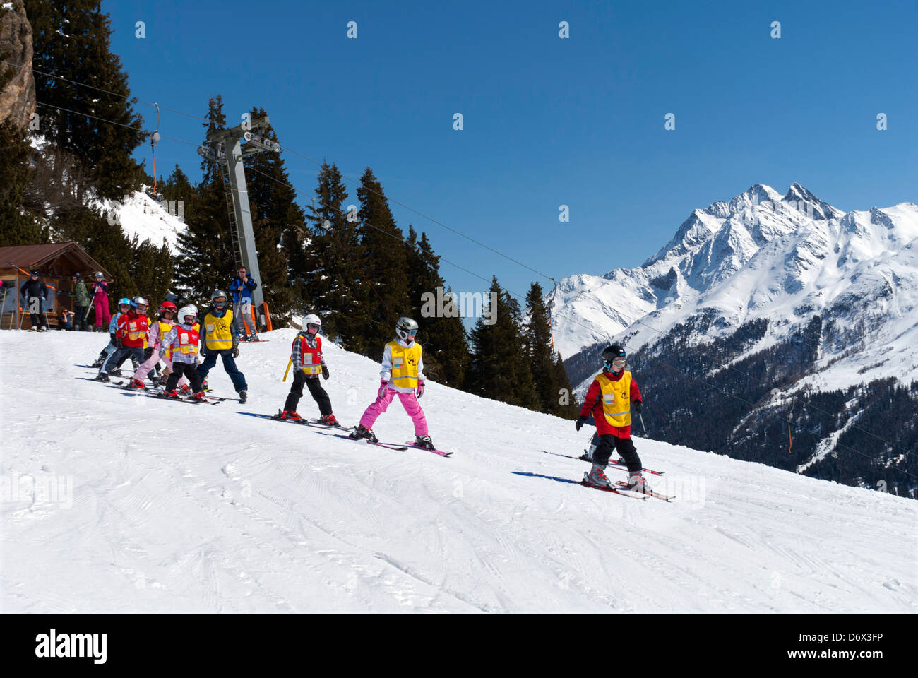 Class of young children learning to ski, on the slopes above St Anton, in the Tyrol region of Austria Stock Photo