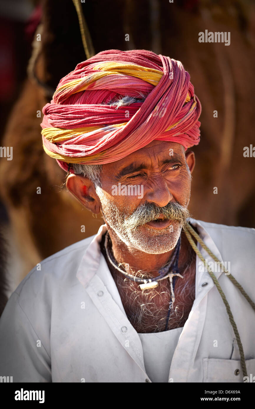 Portrait of india man camel rider wearing red turban, Bishnoi, India Stock Photo