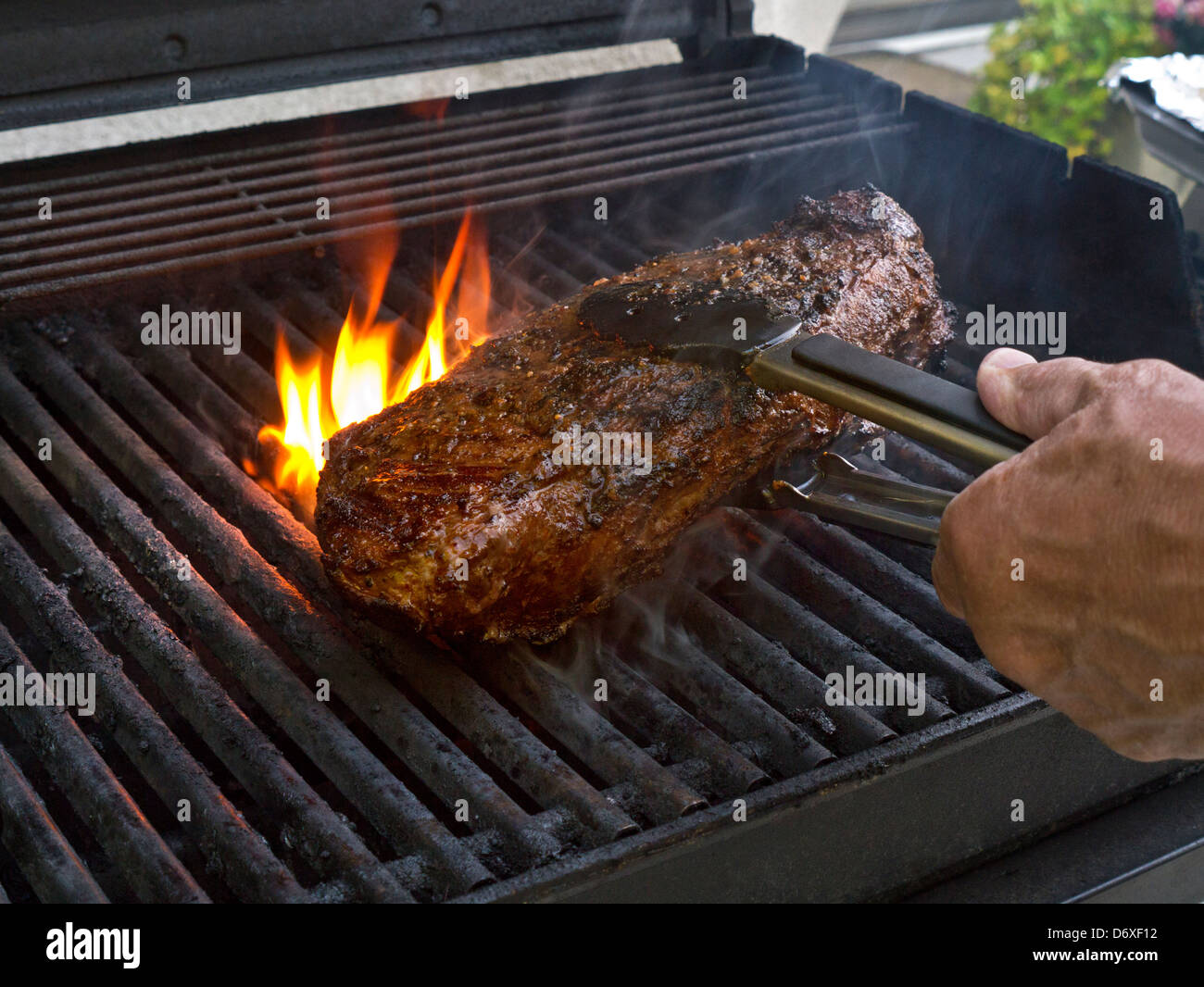 American cut sirloin of beef on Californian flame barbeque outdoors Stock Photo