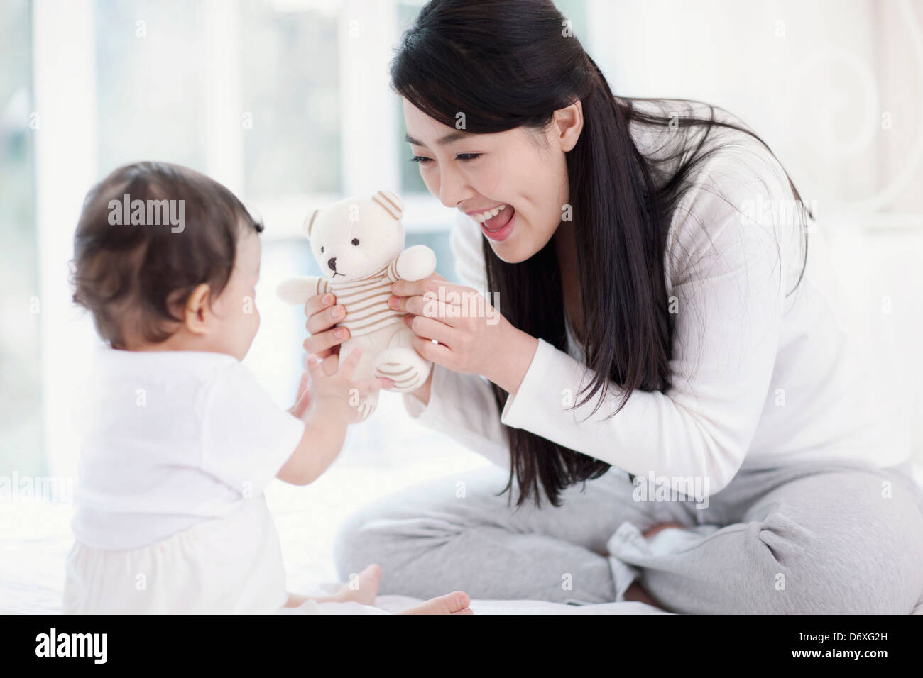 mother and baby playing with teddy bear Stock Photo - Alamy