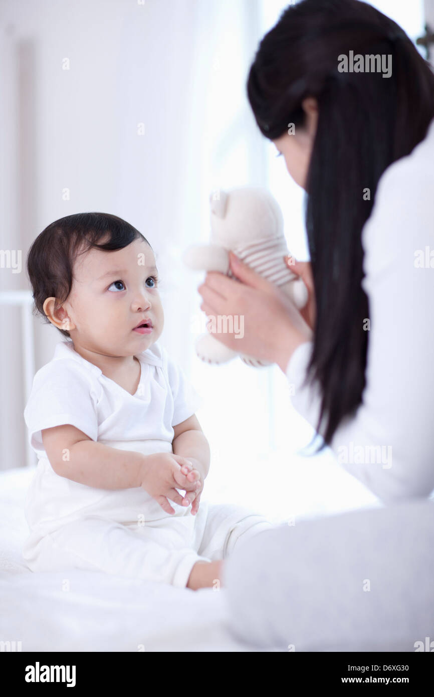 mother and baby playing with teddy bear Stock Photo - Alamy