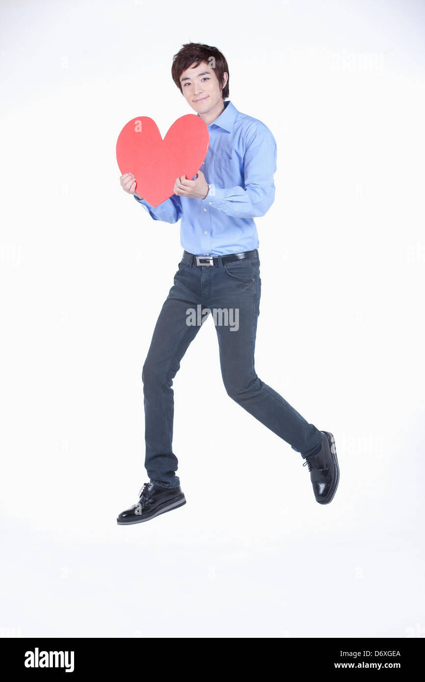a man holding a heart in white background Stock Photo - Alamy