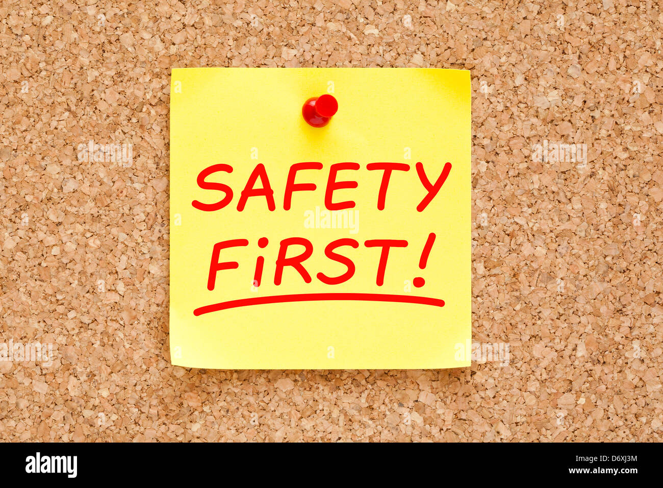Safety First written on yellow sticky note with red marker. Stock Photo