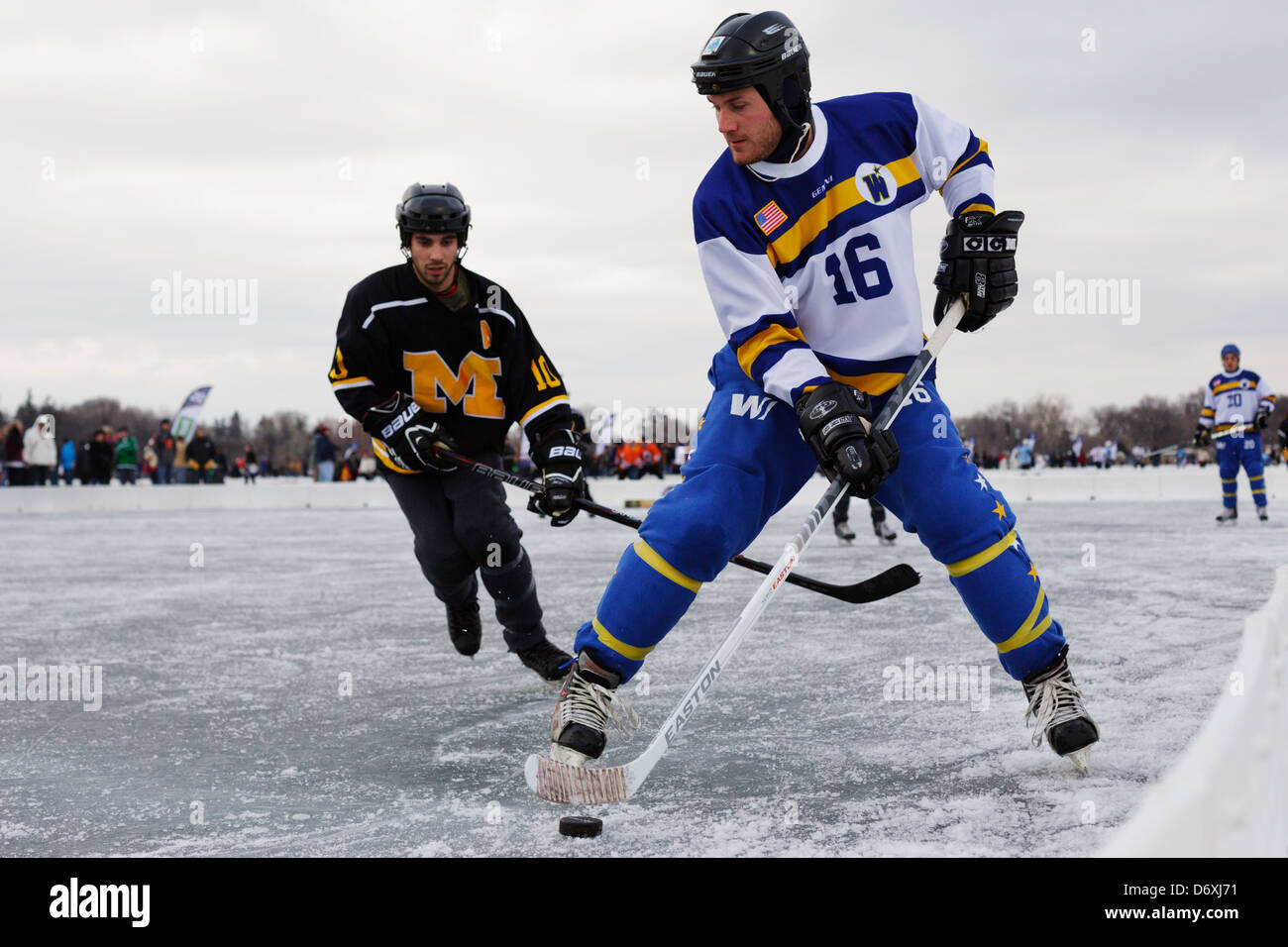 A player controls the puck during a game at the U.S. Pond Hockey Championships on Lake Nokomis on January 19, 2013. Stock Photo