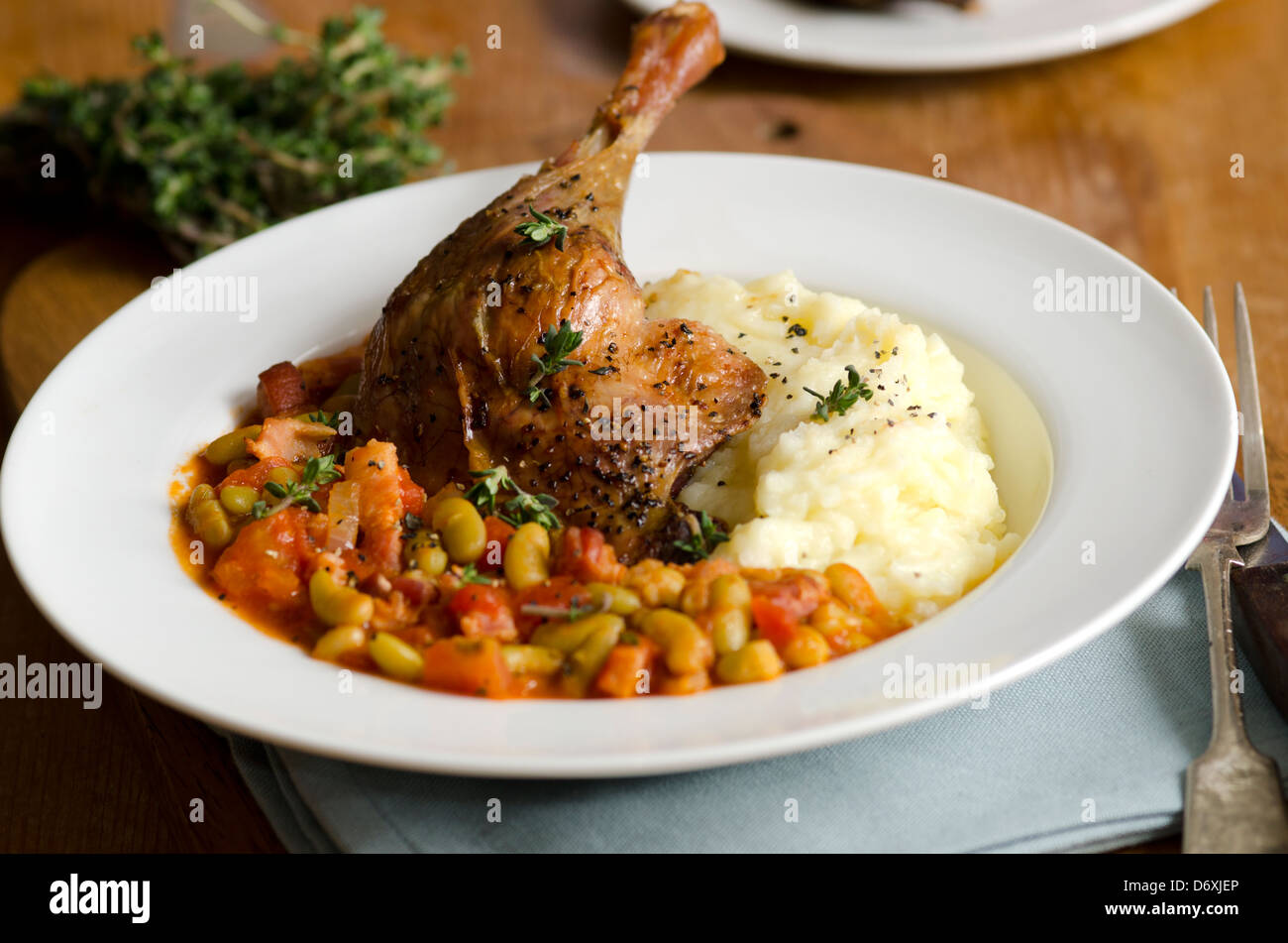 Confit duck leg with beans and mash Stock Photo