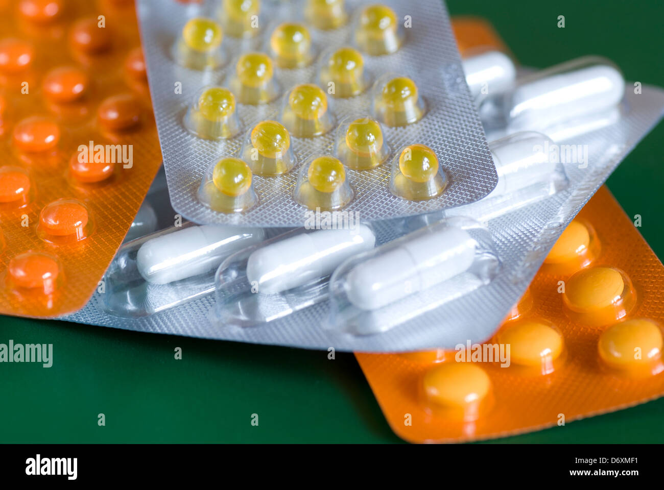 Different kinds of packed pills on green background Stock Photo