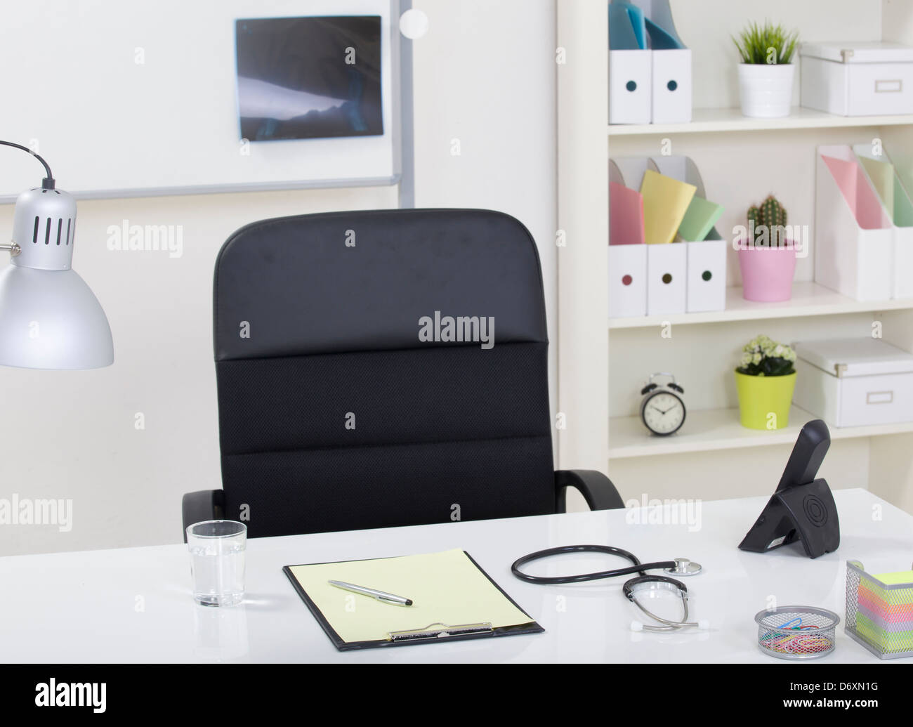 Doctor office table desk and black chair with stethoscope Stock Photo