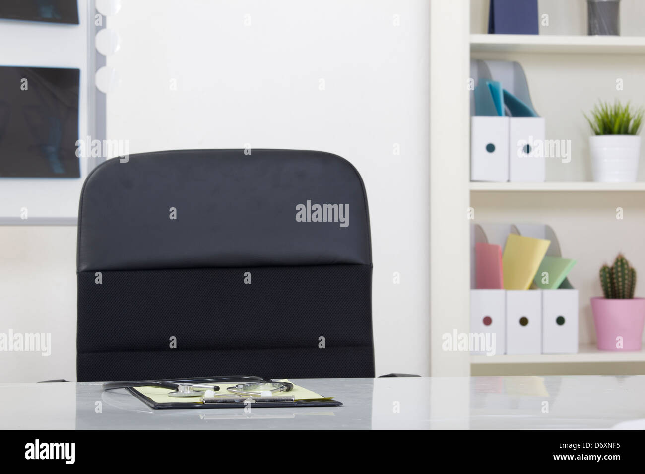 Doctor office table desk and black chair with stethoscope Stock Photo