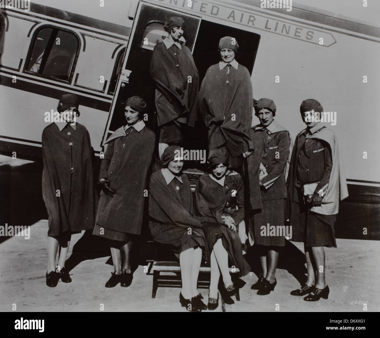 A photograph of United Air Lines stewardesses in uniforms, holding coats, taken during the mid-20th century. This image represents the role of women in aviation, showcasing the professional attire and duties of flight attendants. Stock Photo