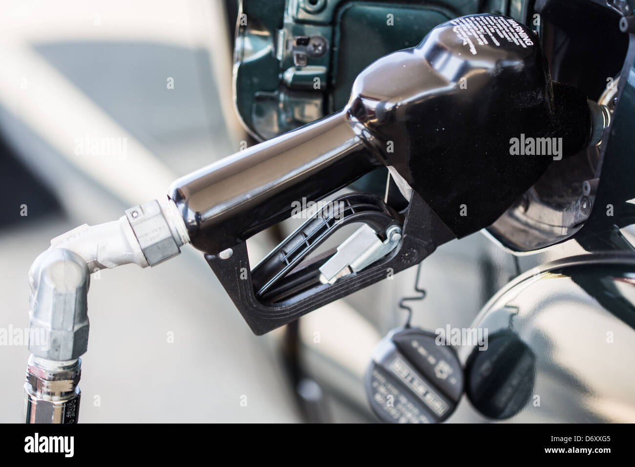 A close up of a gas pump filling up a green pickup truck. Fuel consumption. Stock Photo