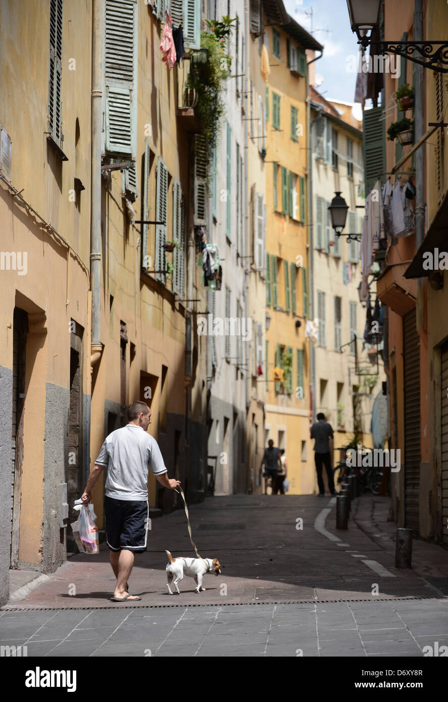 Nice, France, a man is walking his dog in a narrow alley in the Old Town Stock Photo