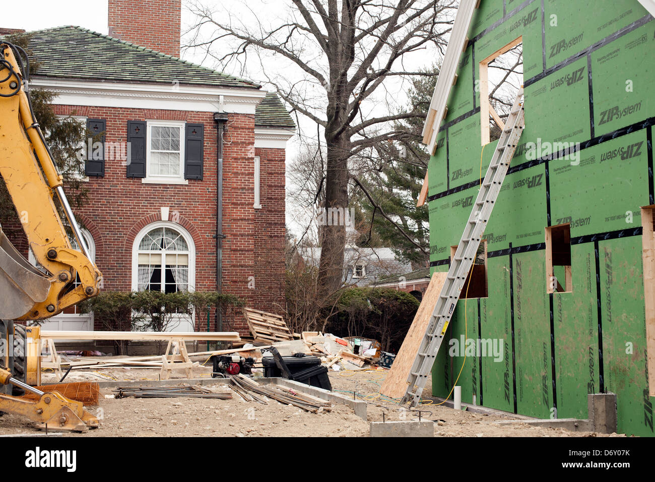 A well-off neighborhood in Brookline Massachusetts has a new home being built very closely to a stately older home. Stock Photo