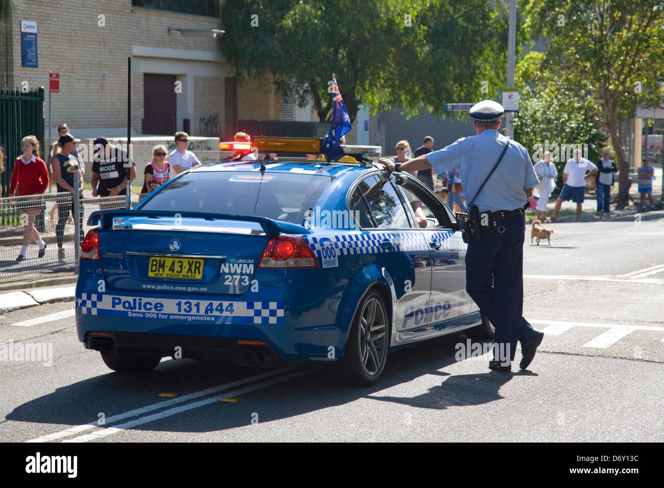 Sydney police officer stood by his police car during ANZAC day march in Sydney,Australia Stock Photo