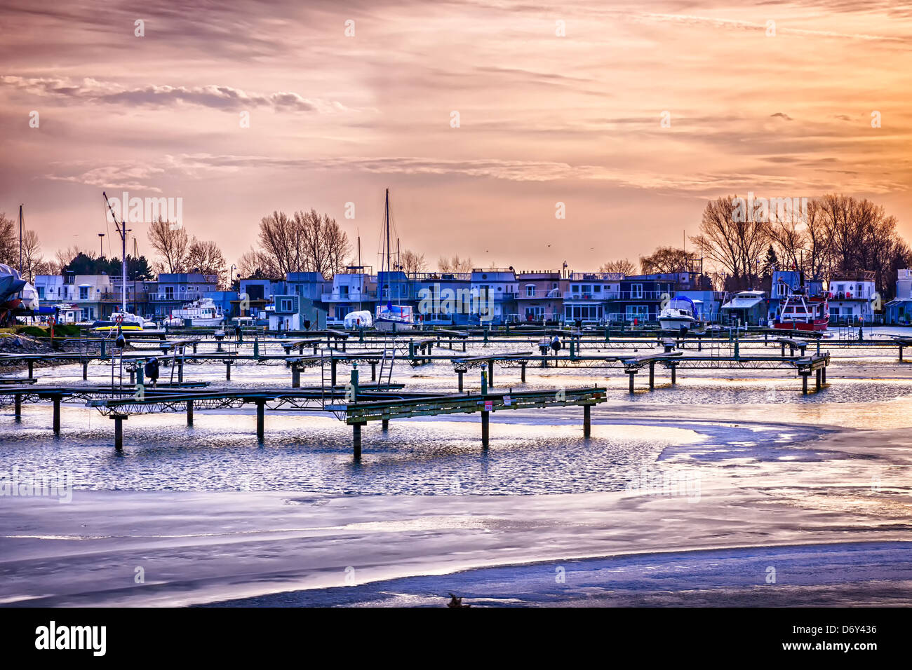 Sunset behind floating homes at Bluffers park marina in Toronto, Canada. Winter. Stock Photo