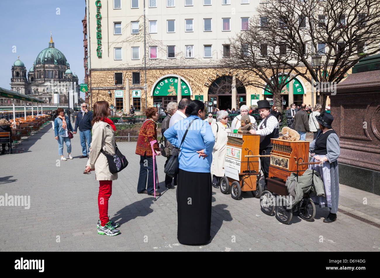 Nikolaiviertel – barrel organ players with tourists watching, Berlin, Germany Stock Photo