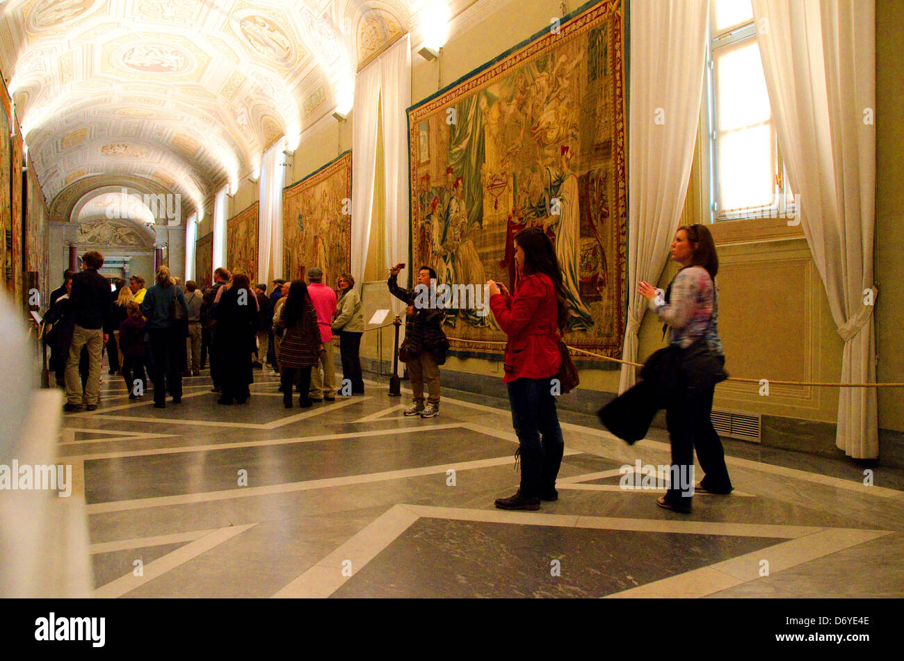Tourists contemplate and photograph art works in the Gallery of Tapestries, Vatican Museums, Vatican City Stock Photo