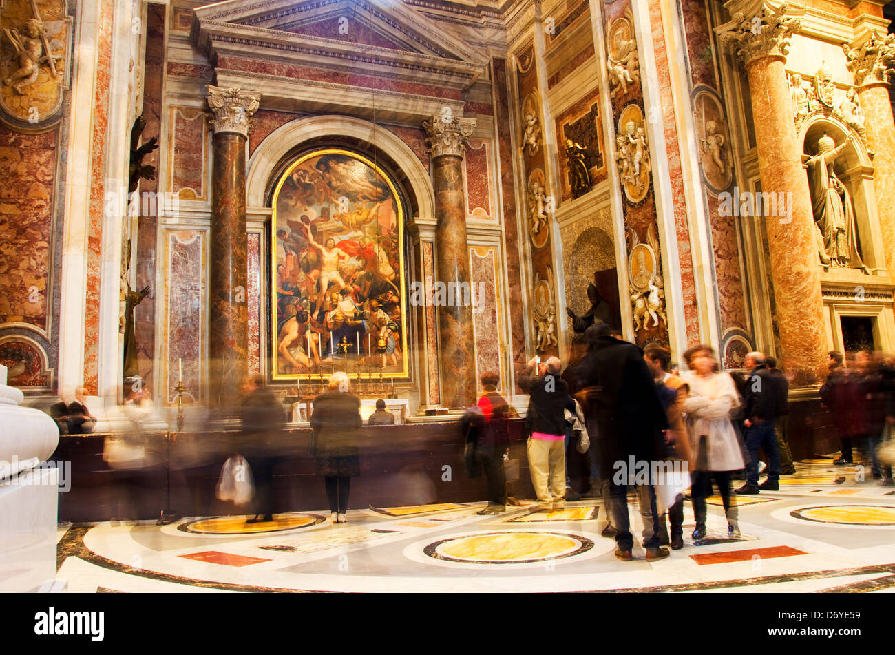 Tourists contemplate an ornate altar within the St. Peter's Basilica, Vatican City Stock Photo
